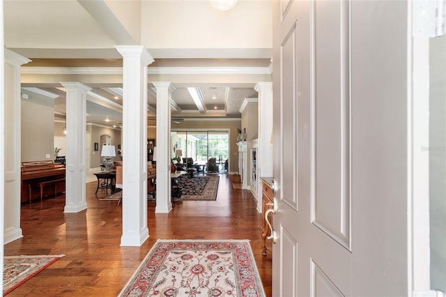 foyer with decorative columns, dark wood finished floors, and ornamental molding