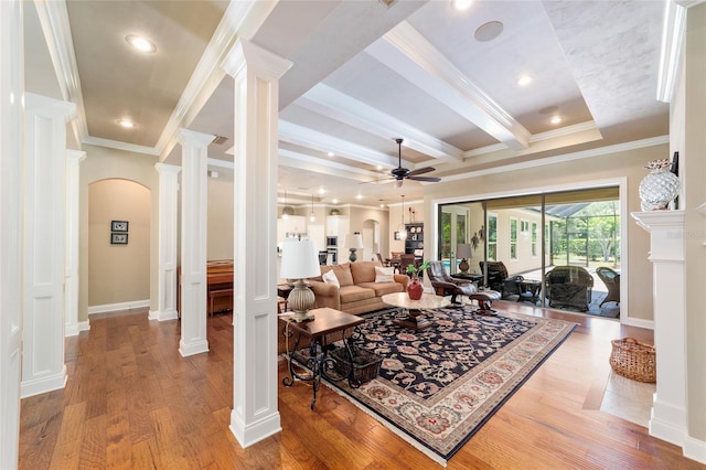 living room with decorative columns, ceiling fan, arched walkways, crown molding, and wood finished floors