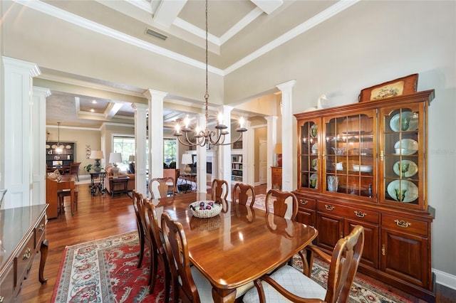 dining area featuring decorative columns, coffered ceiling, a chandelier, dark wood finished floors, and ornamental molding