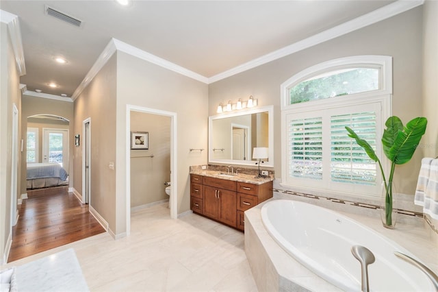 ensuite bathroom with ornamental molding, a garden tub, toilet, vanity, and recessed lighting