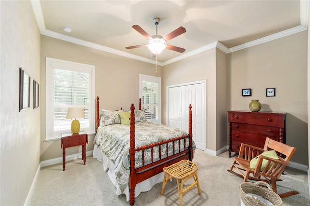 bedroom with ornamental molding, light colored carpet, baseboards, a closet, and ceiling fan