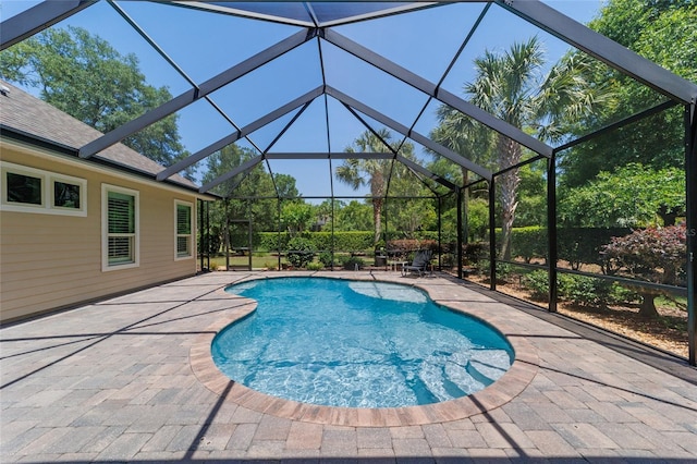 swimming pool featuring a patio area and glass enclosure