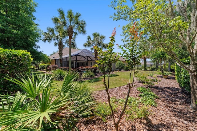 view of grassy yard featuring glass enclosure