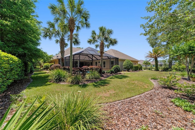 view of grassy yard featuring glass enclosure