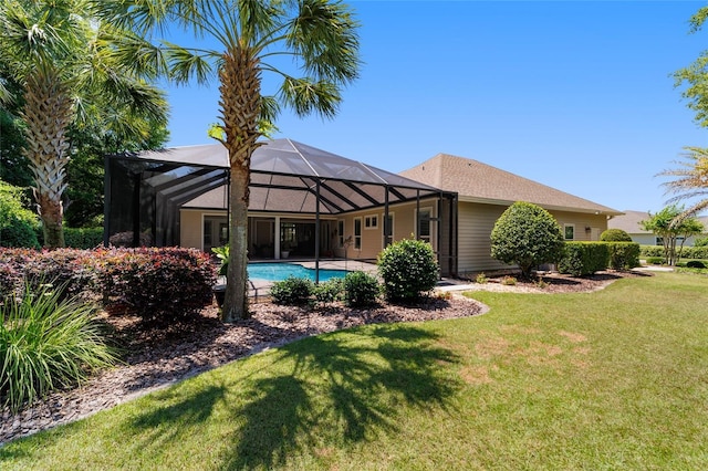 back of house with a lawn, a lanai, and an outdoor pool