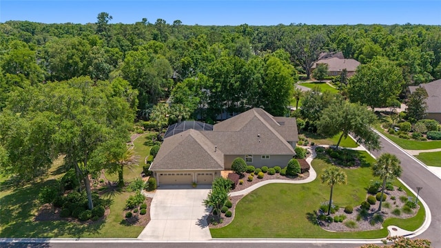 aerial view of property and surrounding area featuring a forest