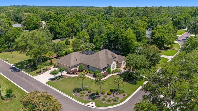aerial view of property and surrounding area with a heavily wooded area