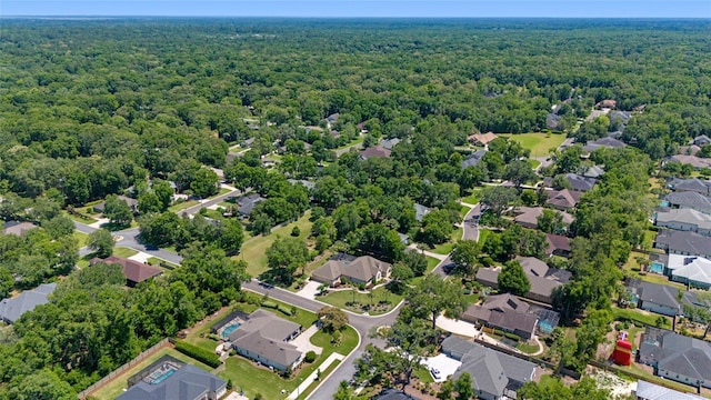 aerial view of property's location featuring a forest and nearby suburban area