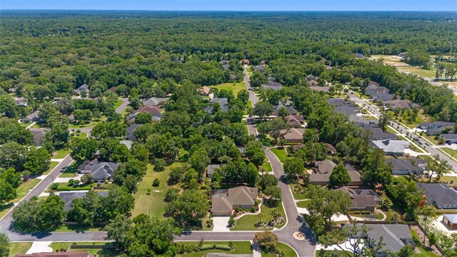 view of property location featuring a heavily wooded area and nearby suburban area