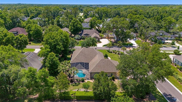 aerial view of residential area with a pool area and a heavily wooded area