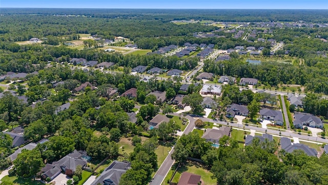 aerial overview of property's location featuring a forest and nearby suburban area