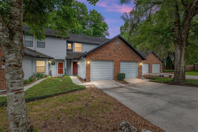 938 NW 42nd Ter, Gainesville, FL 32605 - view of front of property featuring brick siding, driveway, an attached garage, and a shingled roof