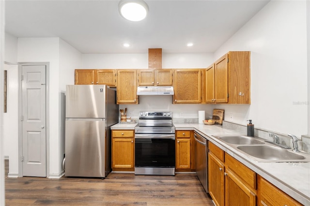 938 NW 42nd Ter, Gainesville, FL 32605 - kitchen with appliances with stainless steel finishes, a sink, under cabinet range hood, dark wood finished floors, and light countertops