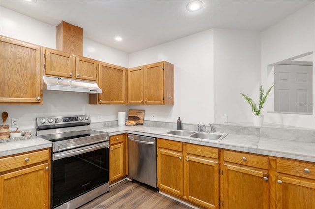 938 NW 42nd Ter, Gainesville, FL 32605 - kitchen featuring appliances with stainless steel finishes, under cabinet range hood, a sink, dark wood finished floors, and light countertops