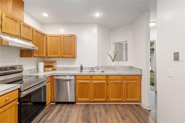 938 NW 42nd Ter, Gainesville, FL 32605 - kitchen featuring appliances with stainless steel finishes, a sink, under cabinet range hood, dark wood-type flooring, and recessed lighting