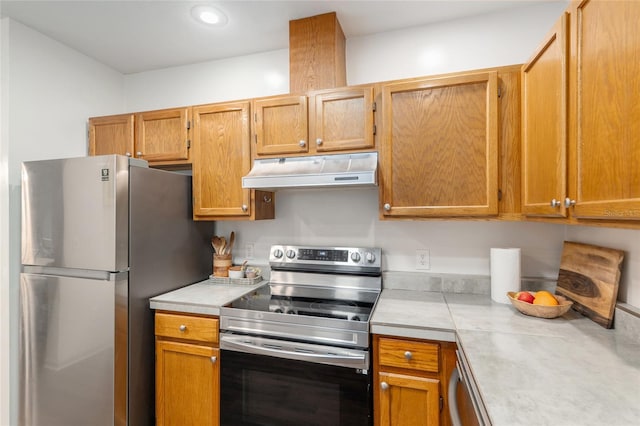 938 NW 42nd Ter, Gainesville, FL 32605 - kitchen with under cabinet range hood, stainless steel appliances, tile countertops, and recessed lighting