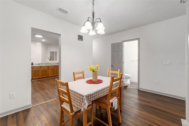 938 NW 42nd Ter, Gainesville, FL 32605 - dining space featuring dark wood-type flooring, a chandelier, and baseboards