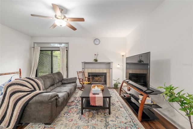 938 NW 42nd Ter, Gainesville, FL 32605 - living area featuring a tiled fireplace, ceiling fan, and wood finished floors