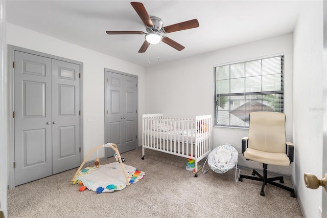 938 NW 42nd Ter, Gainesville, FL 32605 - bedroom featuring carpet floors, two closets, a ceiling fan, and a crib