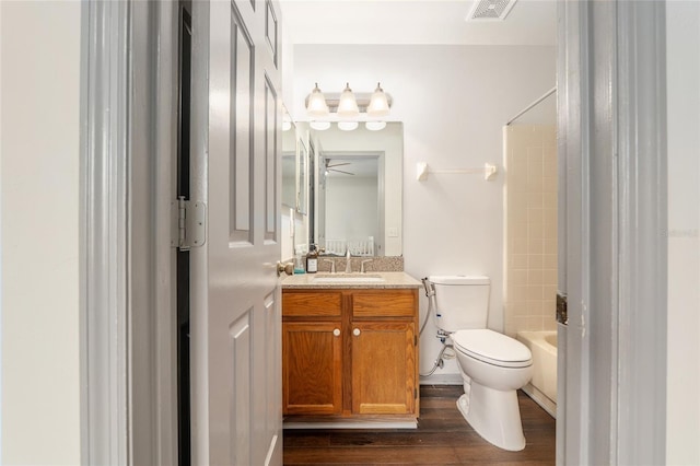 938 NW 42nd Ter, Gainesville, FL 32605 - bathroom featuring toilet, wood finished floors, vanity, and washtub / shower combination