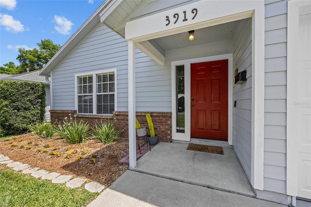 view of exterior entry with brick siding