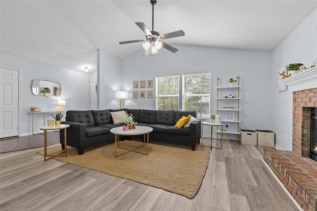 living room featuring a fireplace, ceiling fan, vaulted ceiling, and wood finished floors