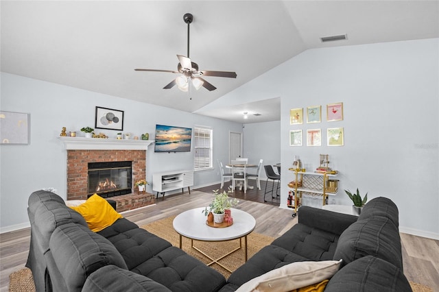 living room with lofted ceiling, visible vents, ceiling fan, baseboards, and light wood-style floors