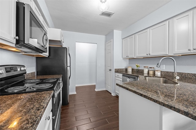 kitchen with visible vents, a sink, white cabinetry, dark wood-type flooring, and stainless steel appliances