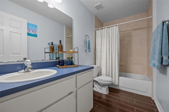 full bath featuring toilet, visible vents, vanity, wood finish floors, and shower / bathtub combination with curtain