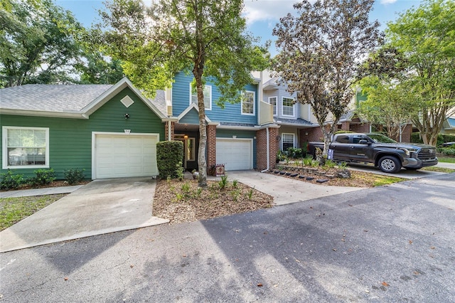 townhome / multi-family property with brick siding and driveway