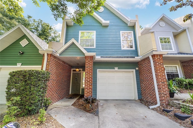 view of front of property featuring concrete driveway, an attached garage, and brick siding