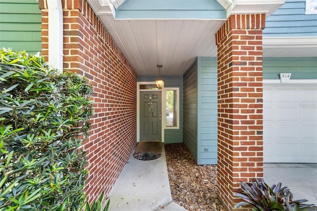 property entrance featuring brick siding and a garage