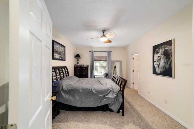 bedroom featuring light colored carpet, baseboards, and a ceiling fan