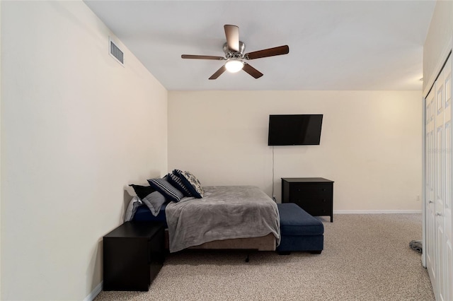 carpeted bedroom featuring baseboards, visible vents, and a ceiling fan