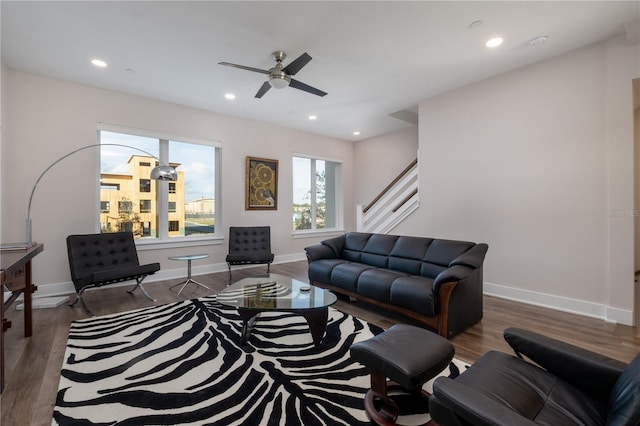living room featuring wood finished floors, a ceiling fan, stairway, baseboards, and recessed lighting