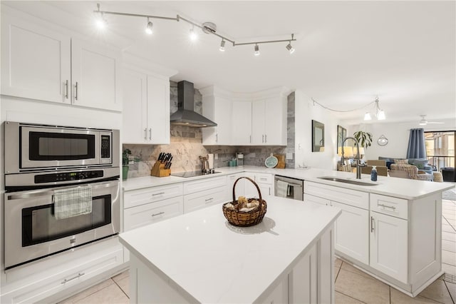 205 Pacifica Vista Way Unit 205, Saint Augustine, FL 32080 - kitchen featuring a sink, a peninsula, light tile patterned flooring, wall chimney exhaust hood, and appliances with stainless steel finishes