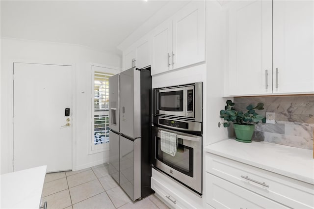 205 Pacifica Vista Way Unit 205, Saint Augustine, FL 32080 - kitchen with stainless steel appliances, tasteful backsplash, light tile patterned floors, light countertops, and white cabinets