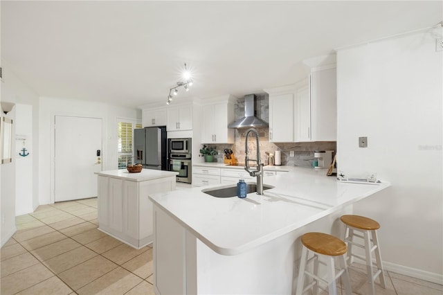 205 Pacifica Vista Way Unit 205, Saint Augustine, FL 32080 - kitchen with wall chimney range hood, appliances with stainless steel finishes, tasteful backsplash, and light tile patterned floors