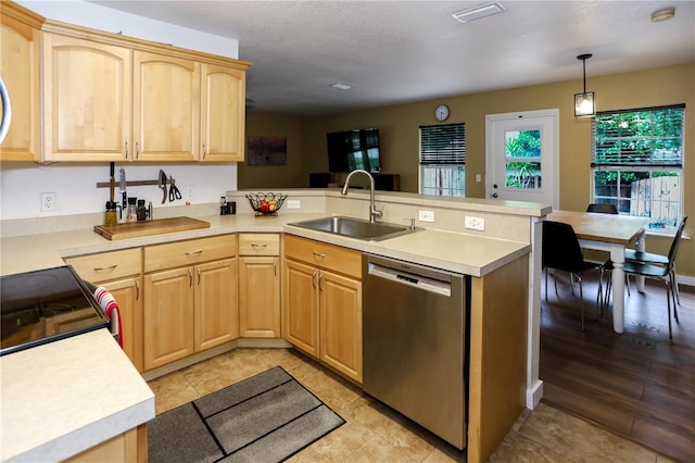 kitchen with stainless steel dishwasher, a sink, light brown cabinetry, a peninsula, and light countertops