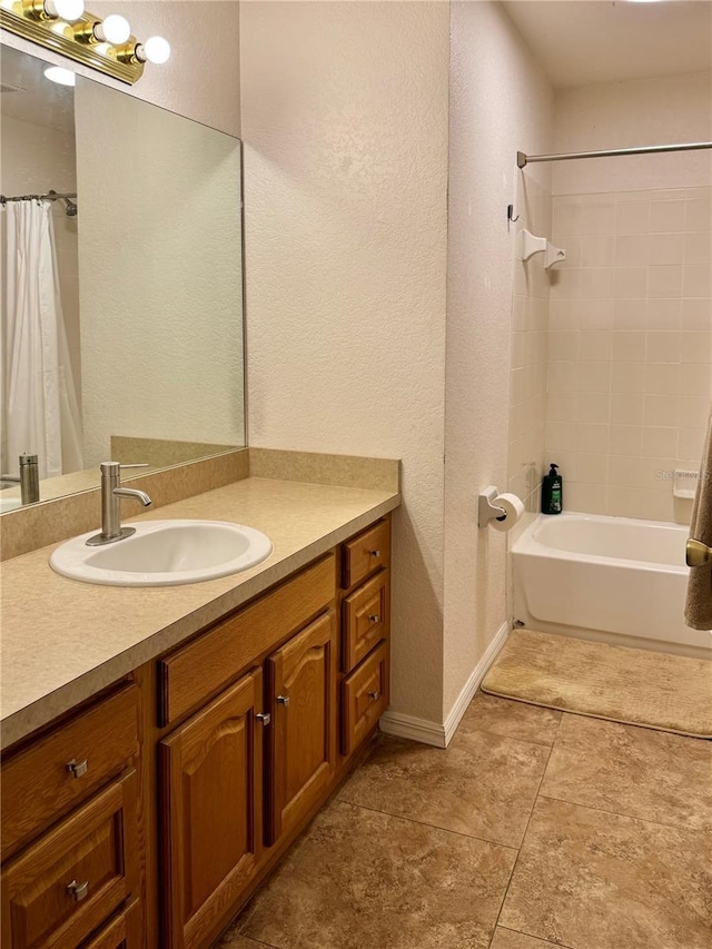 bathroom with vanity, a textured wall, tile patterned flooring, shower / tub combo, and baseboards