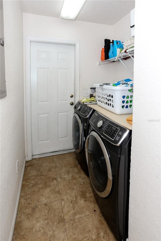 washroom with independent washer and dryer and baseboards