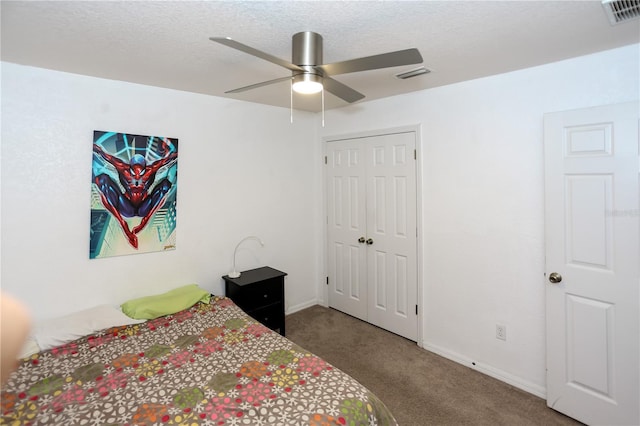 carpeted bedroom featuring baseboards, a closet, ceiling fan, and a textured ceiling