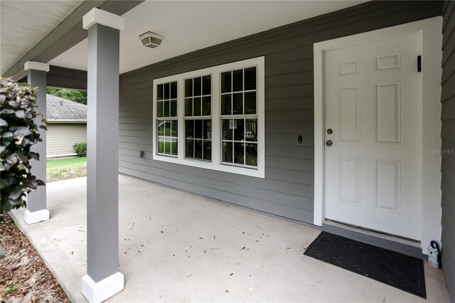 view of exterior entry featuring covered porch