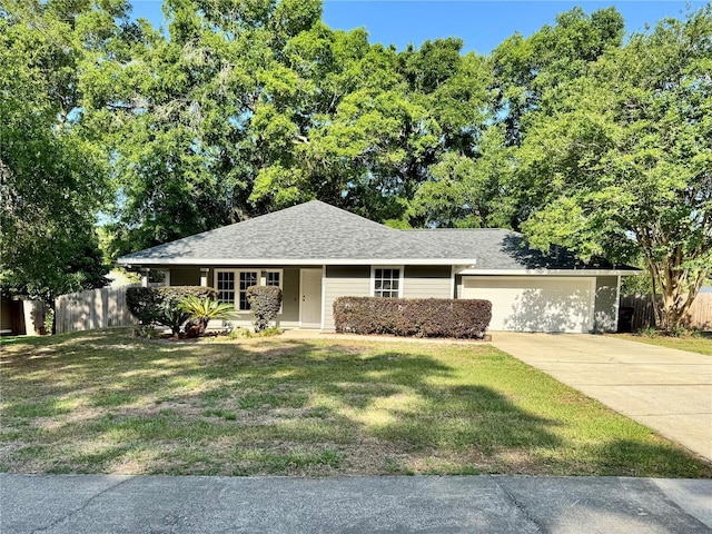 single story home with concrete driveway, an attached garage, and roof with shingles