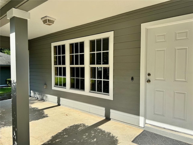 view of exterior entry with a patio area
