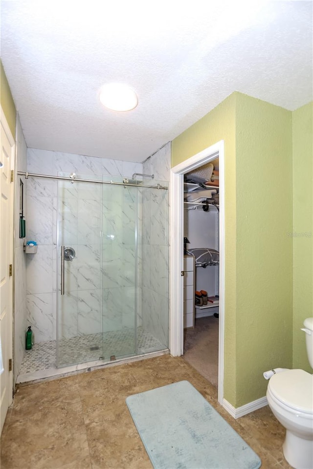 5722 SW 85th St, Gainesville, FL 32608 - full bathroom with a marble finish shower, toilet, a spacious closet, and a textured ceiling