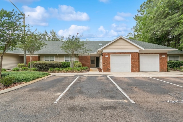 single story home featuring brick siding, a shingled roof, and uncovered parking