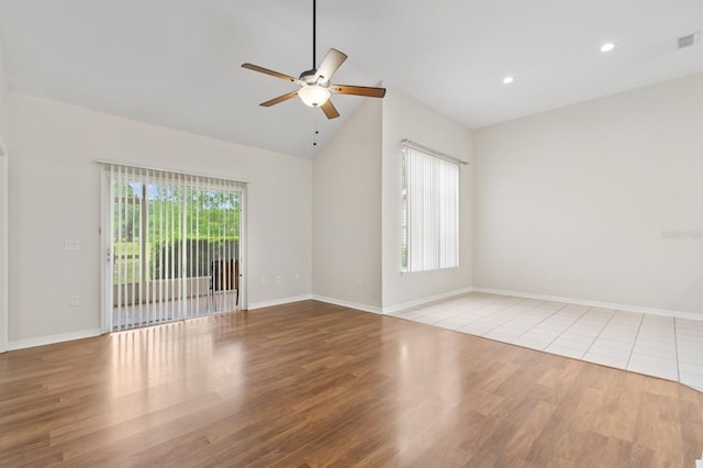 empty room with a ceiling fan, wood finished floors, baseboards, recessed lighting, and high vaulted ceiling
