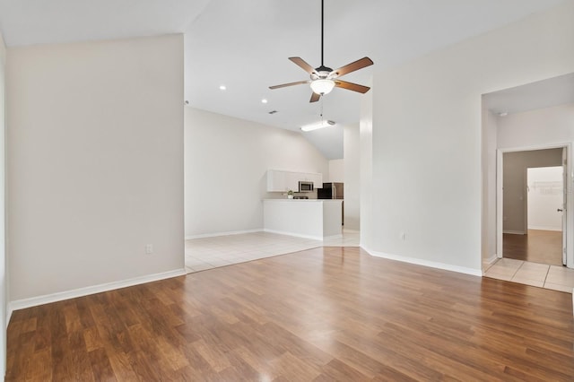 unfurnished living room featuring lofted ceiling, a ceiling fan, light wood finished floors, recessed lighting, and baseboards