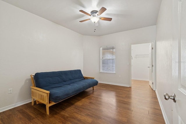 living area with wood finished floors, a ceiling fan, and baseboards